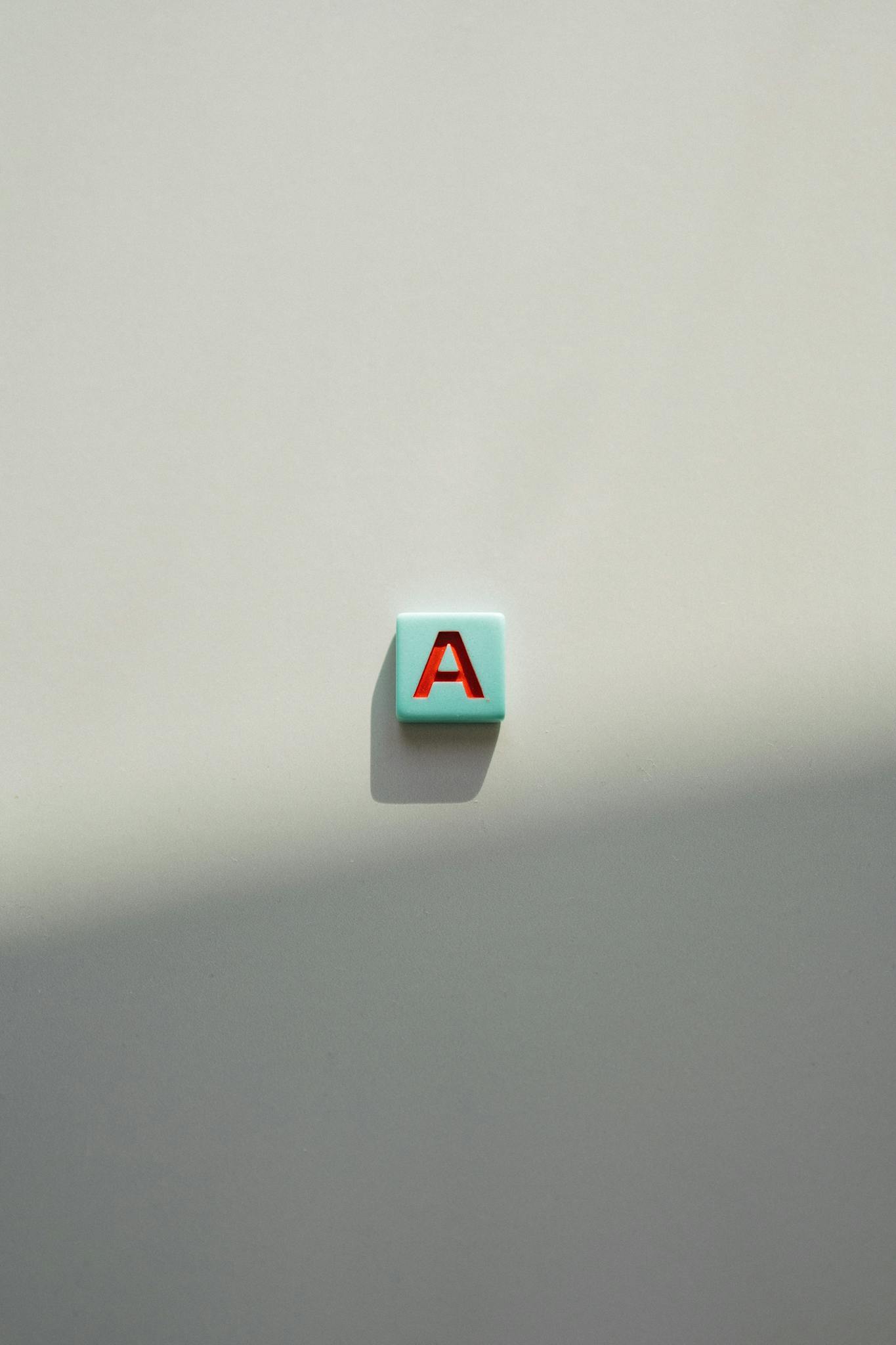 Single letter 'A' tile on a light background, casting a shadow.