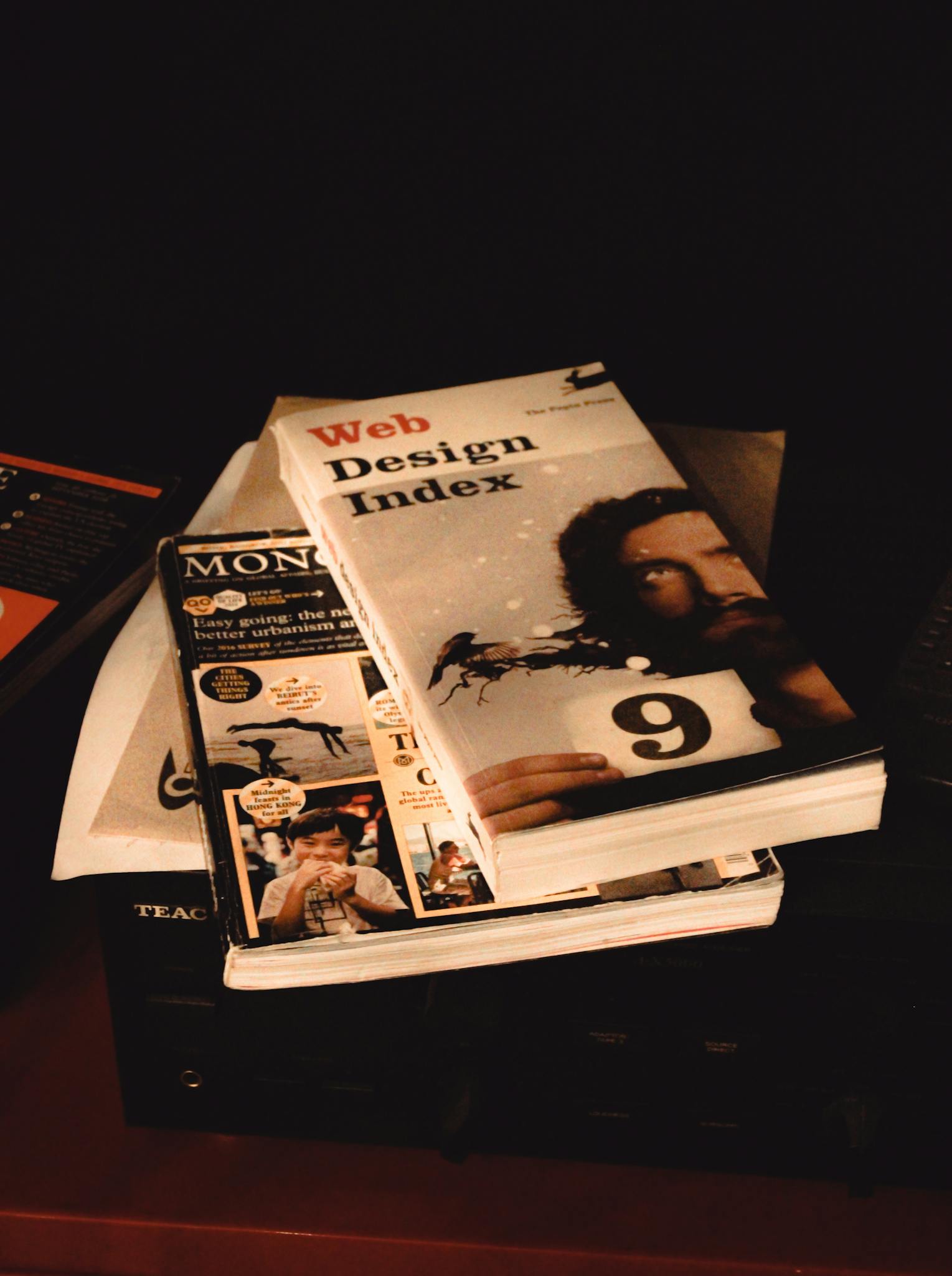 Stack of web design and media books on a shelf, emphasizing creative exploration.